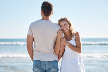 Image showing Couple, hug and love for travel, beach or summer vacation relaxing or bonding together in the outdoors. Woman holding man in loving embrace with smile for happy relationship or traveling by the ocean