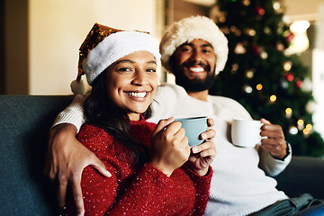 Image showing Christmas, portrait and coffee with a black couple on a sofa in the living room of a home to relax together. Happy, smile and love with a man and woman bonding in celebration of the festive season