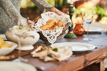 Image showing Food, bread and party with hands of woman at dinner table for hospitality, holiday or celebration. Culinary, decoration and lunch with girl serving for feast, health and festive nutrition in outdoor