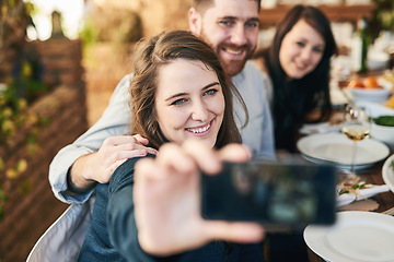 Image showing Friends, selfie and dinner with party and celebration, woman holding smartphone for photo and Christmas or Thanksgiving dinner party. Happy, celebrate and food, having meal together and smile.