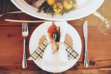 Image showing Plate, Christmas and celebration with a table setting on a wooden surface in the festive season from above. Party, still life and cutlery with a napkin on a serving dish in an empty home with flare