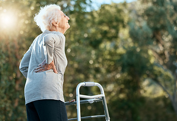 Image showing Senior woman, back pain and walking frame for rehabilitation at park for exercise for arthritis, fibromyalgia or osteoporosis problem. Old woman in nature for air, hope and freedom in retirement