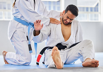 Image showing Karate, sports and neck injury pain of fighter on floor with surrender hand at professional athlete club. Accident, help and tournament of martial arts person in agony with muscle pain.