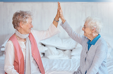 Image showing Elderly woman, friends high five and sitting in bedroom with smile, happy or together in nursing home. Senior women, best friends and happiness with support, empathy and care while on bed in house