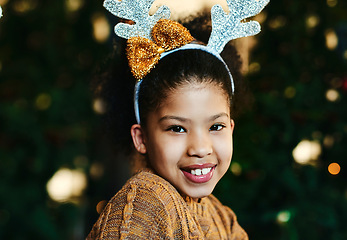 Image showing Christmas, portrait and children with a girl in antlers on a dark background for festive season celebration. Face, smile and kids with a female child wearing reindeer horns headwear in the holidays