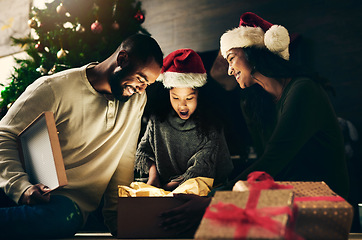 Image showing Happy family, bonding or surprise christmas gift in night house or home living room in celebration event, festive holiday or vacation. Smile, happy or shocked child, xmas mother or father and present
