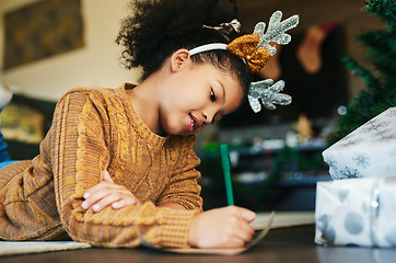 Image showing Child, christmas and writing letter, list of wishlist for gift or present from santa claus with hope to celebrate holiday with happiness at home. Girl kid with pencil to write note or xmas card