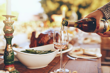 Image showing Champagne, dinner and hands with a woman pouring a drinking during a Christmas party outdoor. Tradition, celebration and alcohol with a feast on a wooden table for a social gathering outside