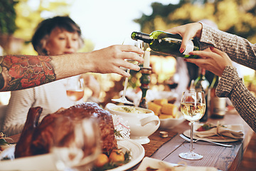 Image showing Dinner, party and celebrate with hands and wine, wine glass to pour for drink, people with food outdoor, holiday or anniversary celebration. Festive, event and table with feast, friends and family.