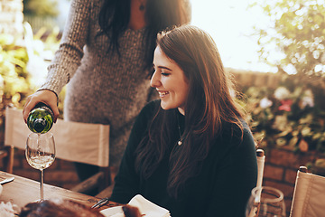 Image showing Dinner party, nature and pouring wine for woman sitting at table in restaurant for social event, party and celebration. Festive, alcohol and girl enjoying vacation, holiday and weekend at vineyard