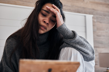 Image showing Sad, depression and woman with frame in home looking at photo, feeling grief for death or loss. Mental health, anxiety or lonely female thinking of problems or frustrated after breakup alone in house