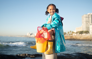 Image showing Ocean, fishing and portrait of girl with smile sitting on dock, fun and happy day at beach holiday on the weekend. Nature, blue sky and waves, child at the sea with net ready to catch fish in water