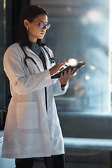 Image showing Doctor, tablet and woman planning at night in medical office, hospital and clinic for research, test results information and connection. Focus healthcare worker, telehealth and digital app technology