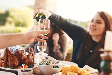 Image showing Party, dinner and woman pouring wine in a wine glass to cheers at an outdoor celebration feast. Champagne, toast and girl serving a luxury alcohol drink at event in nature or backyard garden at home.