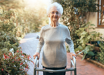 Image showing Disability, rehabilitation and senior woman with walking frame for outdoor wellness, moving body and healthcare in nature, garden or park. Retirement home, elderly care and old lady portrait on walk