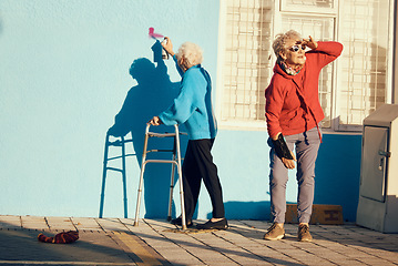 Image showing Senior women, friends and spray paint for vandalism, graffiti and street art drawing on nursing home building wall. Crazy old people break law with illegal pop art outdoor in retirement for fun