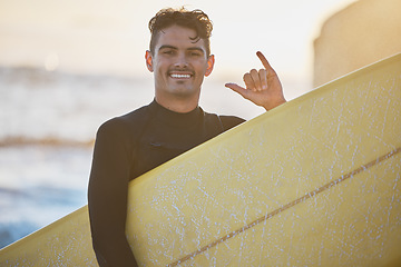 Image showing Man, surfer and shaka in beach portrait with surfboard, smile or hang loose sign in outdoor sunshine. Happy, ocean and guy with hang ten hand, summer sunset or surfing by sea for water sport exercise