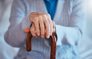 Image showing Hands, cane and disability with a senior woman closeup in her home alone with a walking stick for mobility. Health, medical and wellness with a mature female in a retirement home with hand wrinkles