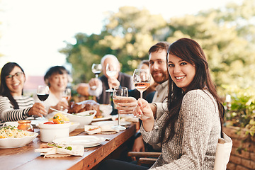 Image showing Toast, wine and family at lunch in a garden during a Christmas party on the patio. Food, alcohol and portrait of friends with a cheers and eating at a table during a celebration in a backyard
