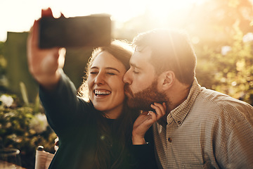 Image showing Couple, kiss and phone for happy selfie, love or relationship bonding moments together in nature. Man and woman with smile for loving romance, travel or vacation photo with smartphone in the outdoors