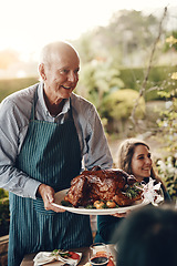 Image showing Chicken, celebration and man serving lunch on Christmas holiday, family gathering and event in a backyard. Food, cooking and chef with a turkey for hungry people at a Thanksgiving dinner party