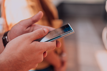 Image showing Closeup photo of businessman hand utilizes his smartphone outdoors, showcasing the seamless integration of technology and mobility in modern professional life.