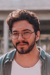 Image showing A portrait of a modern man, exuding confidence and style, against an outdoor backdrop, showcasing his charisma and fashionable demeanor.