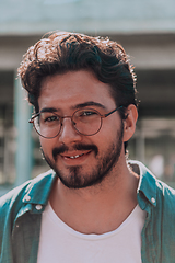 Image showing A portrait of a modern man, exuding confidence and style, against an outdoor backdrop, showcasing his charisma and fashionable demeanor.