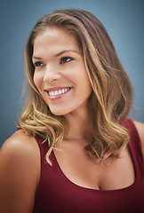 Image showing Thinking, happy and woman with a vision, smile and happiness against a blue background in studio. Idea, hair care and face of a salon model with natural beauty, young and confident on a wall