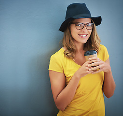 Image showing Fashion, glasses and woman with coffee on wall with cappuccino, espresso and mock up space background. Aesthetics, designer hat and trendy female from Canada holding tea or hot beverage with mockup.