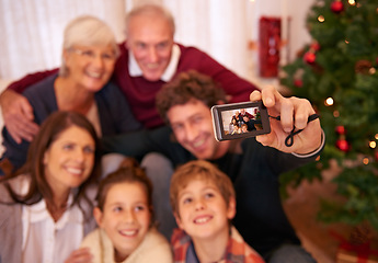 Image showing Happy, family, camera and selfie in living room for christmas, bonding and relax in their home together. Happy family, photography and generations embrace and pose for festive picture, happy and joy