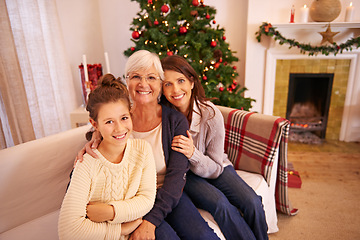 Image showing Grandmother, mother and girl on sofa at Christmas enjoying holiday, vacation and festival celebration. Family, love and and portrait of mom bonding with grandma and child with Christmas tree in home