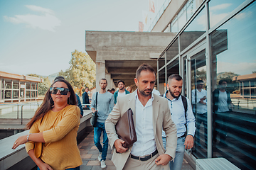 Image showing A diverse group of businessmen and colleagues walking together by their workplace, showcasing collaboration and teamwork in the company.