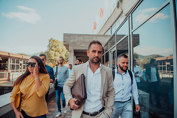 Image showing A diverse group of businessmen and colleagues walking together by their workplace, showcasing collaboration and teamwork in the company.