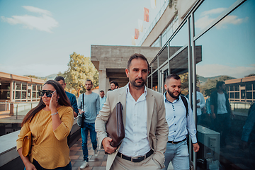 Image showing A diverse group of businessmen and colleagues walking together by their workplace, showcasing collaboration and teamwork in the company.