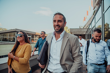 Image showing A diverse group of businessmen and colleagues walking together by their workplace, showcasing collaboration and teamwork in the company.