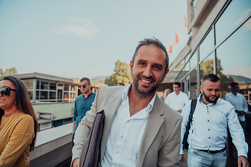 Image showing A diverse group of businessmen and colleagues walking together by their workplace, showcasing collaboration and teamwork in the company.