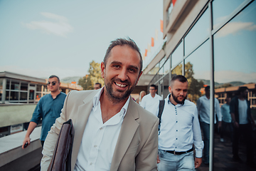 Image showing A diverse group of businessmen and colleagues walking together by their workplace, showcasing collaboration and teamwork in the company.