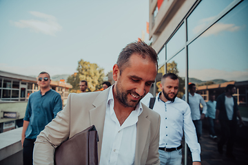 Image showing A diverse group of businessmen and colleagues walking together by their workplace, showcasing collaboration and teamwork in the company.