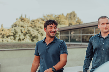 Image showing A diverse group of businessmen and colleagues walking together by their workplace, showcasing collaboration and teamwork in the company.