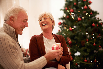 Image showing Happy, love and old couple with a gift for Christmas in celebration of a spiritual celebration at home. Smile, surprise and senior woman enjoys giving fancy presents to an excited elderly partner