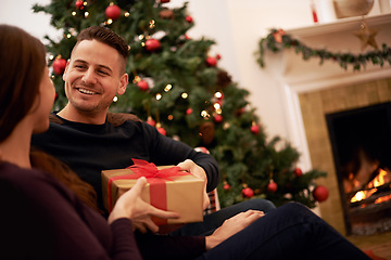 Image showing Christmas, gift and happy family celebration of a man with a present at a holiday party. Couple with love and care on the holidays together with gifting box feeling happiness with a smile at home