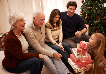 Image showing Christmas, happy family and child with a gift for excited grandparents at home on a winter holiday celebration. Wow, mother and father with a young girl kid giving present boxes to old man and woman