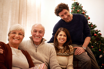 Image showing Christmas, family and visit with a man, woman and senior parents together in the living room of a home. Portrait, happy and bonding with a mother, father and in laws celebrating the festive season