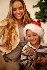 Image showing Christmas, gift and mother with a cat for a child in a celebration of a happy family holiday in the house. Smile, love and mom giving an excited young kid or boy a pet kitten as a present in Canada