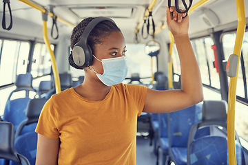 Image showing Travel, face mask and woman on a bus with headphones to listen to music, radio or podcast on the trip. Journey, transport and African girl standing in vehicle with a mask for covid regulations safety