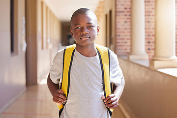 Image showing Education, backpack and portrait of a child at school ready to learn or study in a classroom. Student, knowledge and African boy kid standing with his bag in the hallway at his high school campus.