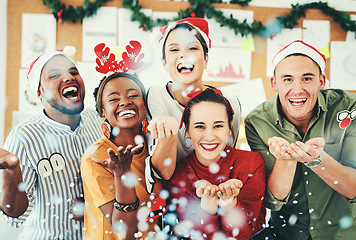 Image showing Christmas, office and business people blowing confetti and having fun together. Portrait, xmas party or group of happy employees, workers or coworkers celebrating with paper decorations in workplace