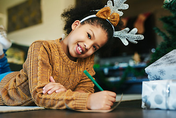 Image showing Christmas, happiness and girl writing a list to Santa Claus for present, gifts and toys for holiday tradition. Festival, celebration and face portrait of child on floor to write letter in family home