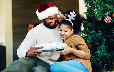 Image showing Father, child and giving christmas gift for holiday celebration with family, love and care while together and happy at home. Man and girl daughter on floor with a surprise present to celebrate xmas